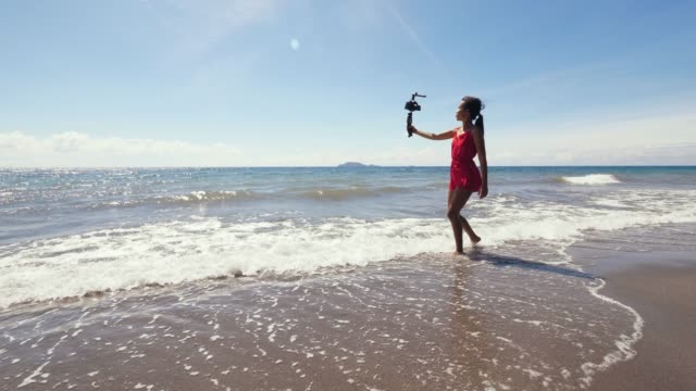 Travel-vlogger-grabación-vlog-en-la-playa-en-verano-mientras-está-de-vacaciones.