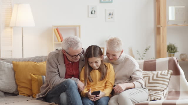 Junge-kaukasische-Mädchen-selfie-mit-Großeltern-auf-Couch