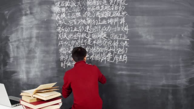 Männliche-asiatische-Bachelor-Schreiben-auf-Blackboard