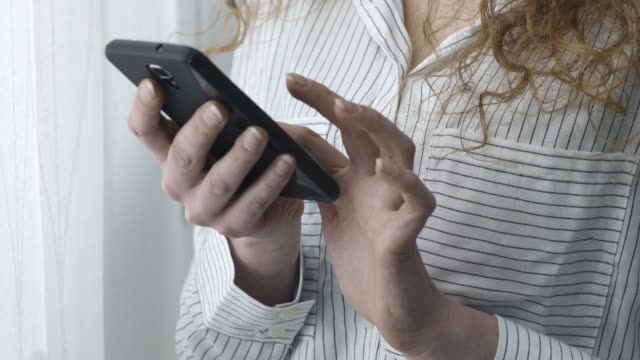 Mensajes-de-texto-de-mujer-joven-con-su-teléfono-inteligente