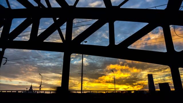 Zeitraffer-Video-eines-Teils-der-Stahlbrücke-mit-Sonnenuntergang-und-schnell-ziehenden-Wolken-im-Hintergrund