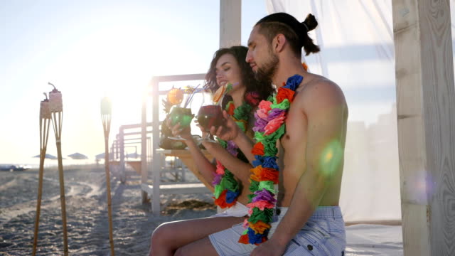 summer-holiday-on-tropical-island,-happy-guy-and-girl-on-beach-party-an-exotic-vacation,-woman-with-male-drink-alcohol-cocktail