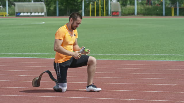 Amputee-Athlete-Pouring-Water-on-Head-while-Training-on-Stadium
