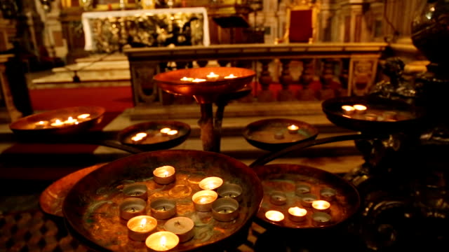 Rounded-burning-candles-standing-in-front-of-altar-of-St.-Januarius,-faith