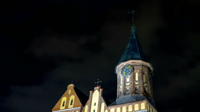Illumination-on-a-historic-building.-Historic-Landmark.-Time-lapse.-Cathedral-of-Kant-in-Kaliningrad.-Old-medieval-castle-at-night-against-the-sky.-An-ancient-tower-with-a-clock.-Timelapse.