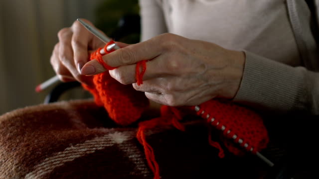 Female-shaking-hands-trying-knit,-concentrating-hobby,-parkinson-disease-symptom