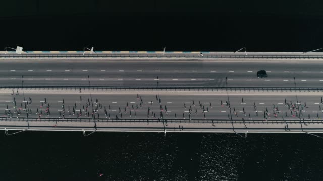 4K-Luftbild-Drohne-Fooage.-Slow-Motion-Marathonlauf-auf-der-Brücke.-Horizontale-Dolly-erschossen-Draufsicht