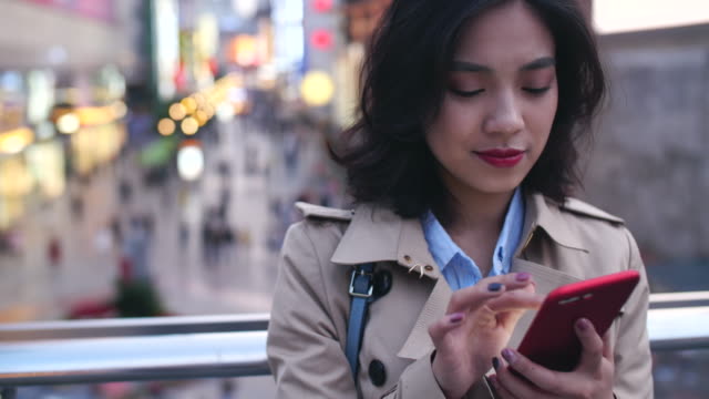 Junge-asiatische-Frau-mit-smartphone-in-der-Stadt