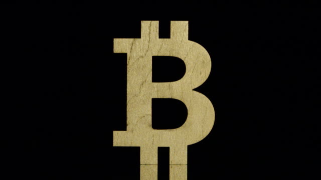 LANGSAM:-Golden-Bitcoin-Symbol-steht-und-fällt-zurück-auf-schwarzem-Hintergrund