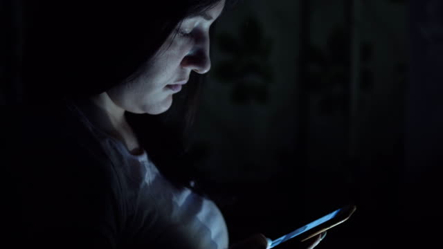 Junge-Frau-sitzt-in-der-Nacht-mit-Telefon-in-sozialen-Netzwerken