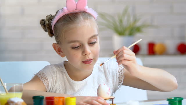 Kleines-Mädchen-in-süße-Stirnband-Färbung-Ei-mit-heller-Farbe,-Kunstschule-für-Kinder