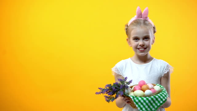 Glückliches-Ostern-Inschrift,-lächelnde-Mädchen-zeigen-Körbchen-mit-Eiern,-Gruß