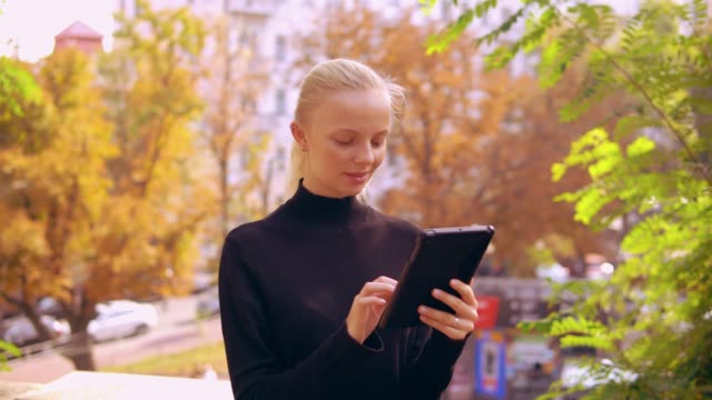 portrait-caucasian-woman-use-digital-tablet-outdoors