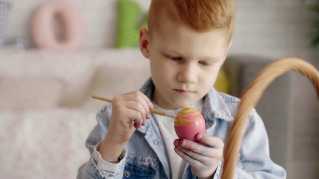 Focused-boy-painting-easter-egg