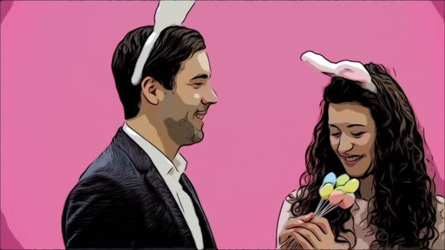 Young-sexy-couple-on-pink-background.-With-hackneyed-ears-on-the-head.-During-this,-rabbit-jumps-recreate-the-movements-and-looks,-after-a-while-go-out-of-the-frame.-Gently-kissed.-Exciting.
