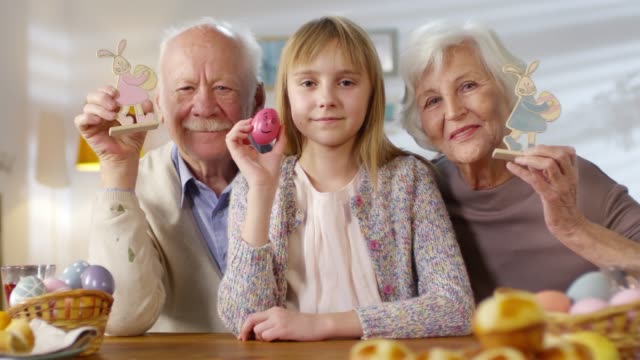 Mädchen-und-Großeltern-halten-Osterspielzeug