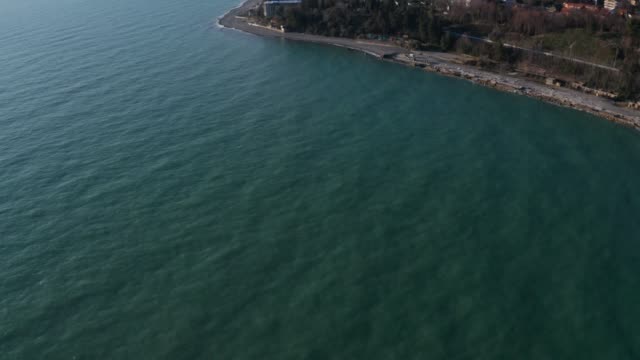 Aerial-video-shooting.-The-view-of-the-blue-sea-and-the-mountains.-City-by-sea.-The-resort-city-of-Sochi.-Panorama-shooting.-Blue-sky,-clear-water-no-people.