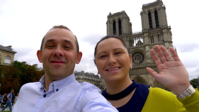 Pareja-tomando-selfie-con-una-vista-de-la-catedral-de-Notre-Dame-en-París-en-4k-cámara-lenta-60fps
