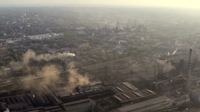 urbane-Skyline-mit-dem-Rauch-aus-den-Pflanzenrohren-über-den-Stadtgebäuden