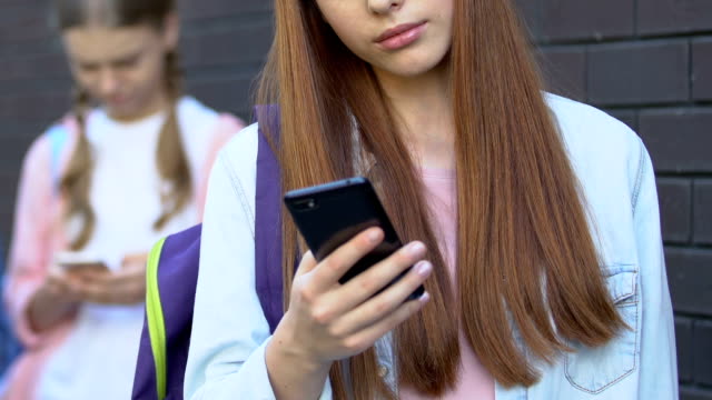 Teen-girls-using-cellphones,-chatting-in-social-network,-internet-addiction