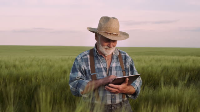 Farmer-verwendet-ein-digitales-Gerät.-Landwirtschaft,-Landwirtschaftliches-Konzept.