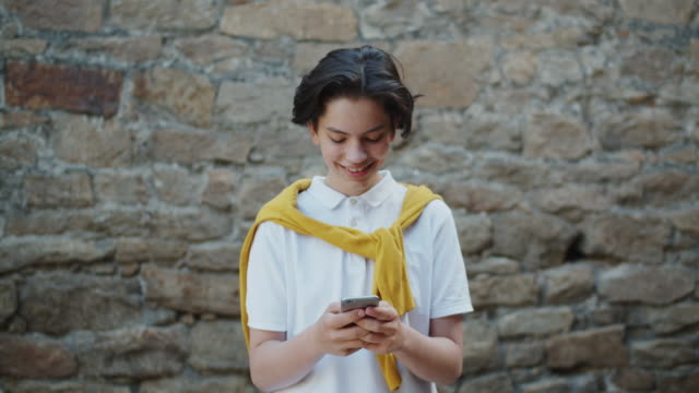 Fröhliche-Teenager-mit-Smartphone-in-der-Straße-lächelnd-Spaß-mit-Gadget