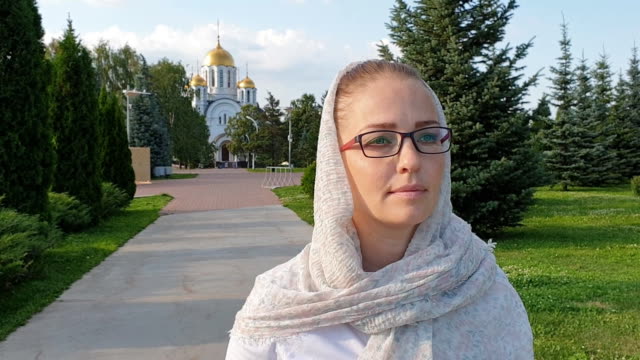 Orthodoxe-Frau-zu-Fuß-im-Park-auf-dem-Hintergrund-der-Kirche