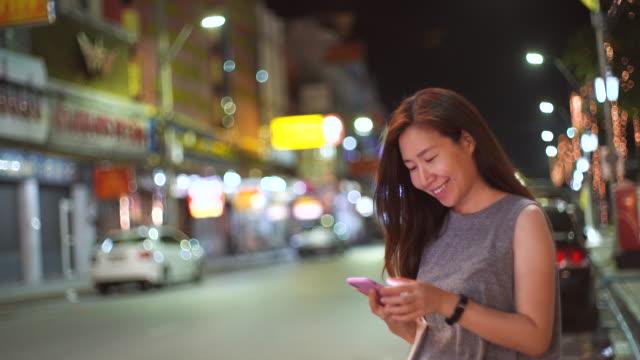 Junge-asiatische-Frau-mit-Smartphone-in-der-Straße-in-der-Nacht,-Lifestyle-Konzept