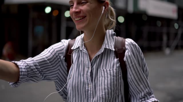 Zeitlupeneffekt-von-fröhlichen-Reiseblogger-in-elektronischen-Kopfhörern