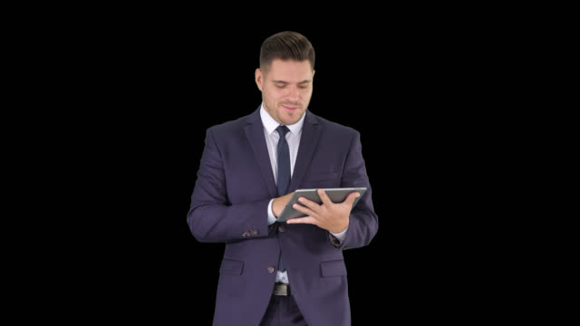 Businessman-swiping-pages-on-a-tablet-and-talking-to-camera-explaining-something-while-walking,-Alpha-Channel