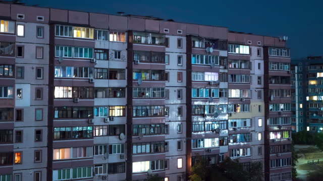 Mehrstöckiges-Gebäude-mit-wechselnder-Fensterbeleuchtung-bei-Nacht.-Zeitraffer