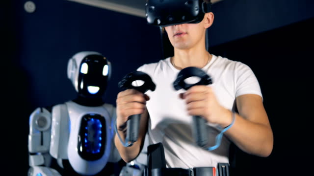 Der-Mensch-verwendet-VR-Ausrüstung,-um-einen-Roboter-in-einem-Raum-aus-nächster-Nähe-zu-steuern.