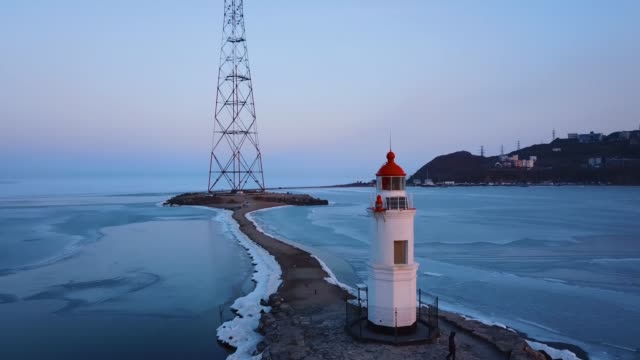 Aerial-winter-view-of-the-Tokarevskiy-lighthouse---one-of-the-oldest-lighthouses-in-the-Far-East,-still-an-important-navigational-structure-and-popular-attractions-of-Vladivostok-city,-Russia.