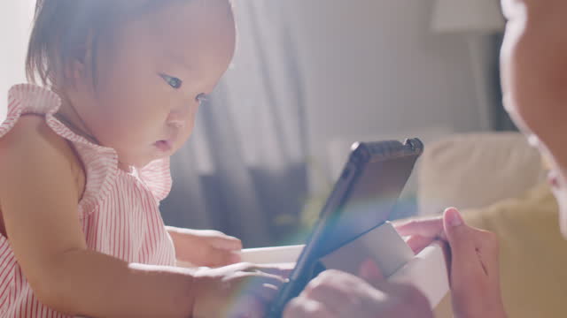 Asiatische-Baby-Mädchen-lernen,-wie-man-Tablet-mit-Mama-verwenden