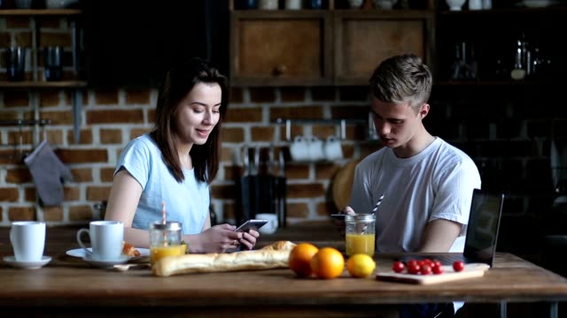 Couple-eating-breakfast-whilst-using-mobile-phones