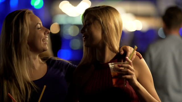 Bisexual-hot-ladies-hugging-and-laughing-on-dance-floor-at-nightclub-party