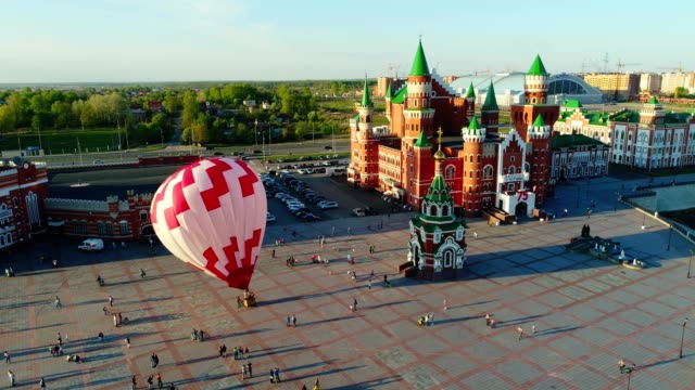 Balloon-is-rising-at-city-square.-Video,-flight-above-Yoshkar-Ola,-Russia