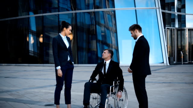 Behinderten-Geschäftsmann-im-Rollstuhl-und-zwei-seiner-Kollegen-hat-positive-Gespräch