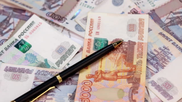 Rotation-pen,-lying-on-the-background-of-rubles
