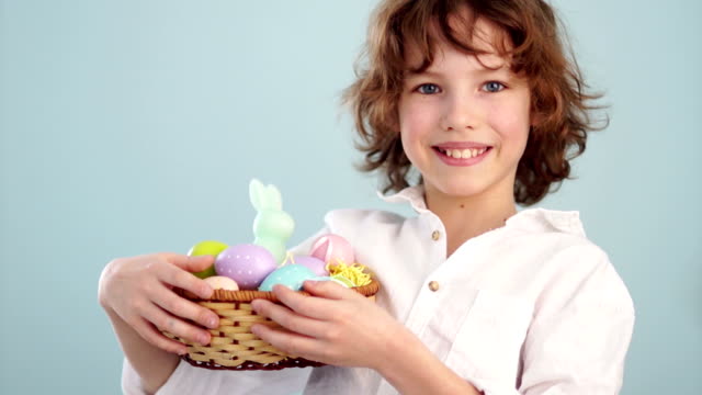 Happy-easter.-A-schoolboy-with-an-Easter-basket-smiling-cheerfully.-Portrait-on-a-blue-background
