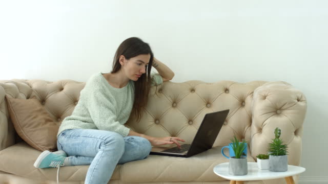 Lässige-hübsche-Frau-Blogging-auf-Laptop-zu-Hause