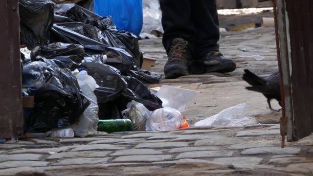 Armut:-Ein-Obdachloser-Bettler-gräbt-in-einer-Mülltonne