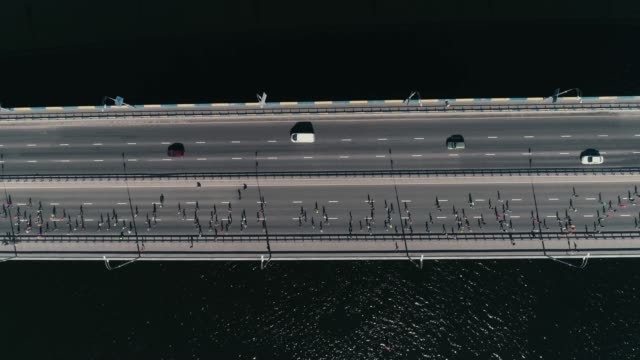 4K-Aerial-drone-fooage.-Marathon-running-on-the-bridge.-Horizontal-movement-dolly-shot-top-view