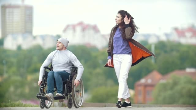Behinderte-Menschen-im-Rollstuhl-zusammen-ihre-Freundin-auf-dem-Kai-gehen