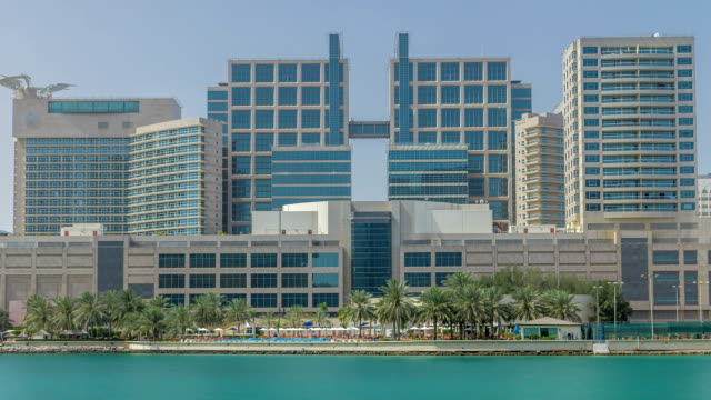 Modern-buildings-in-Abu-Dhabi-skyline-timelapse-with-mall-and-beach