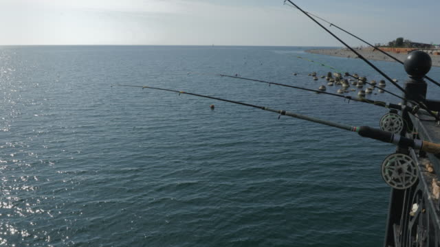 Cañas-de-pescar-y-pesca-equipos-en-el-muelle-junto-al-mar