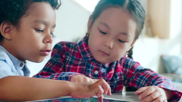Multiethnic-Boy-and-Girl-Playing-on-Digital-Tablet