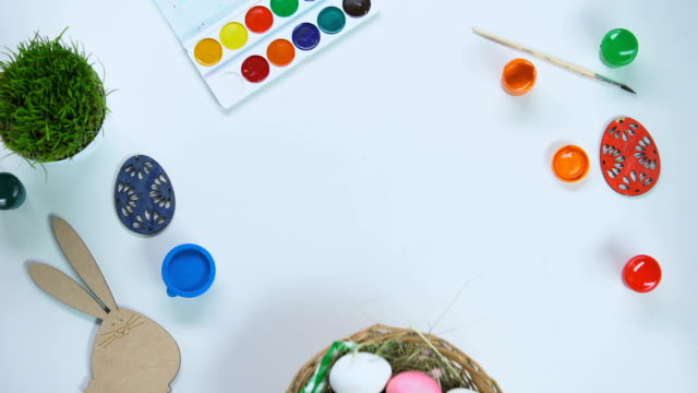 Hände,-Korb-mit-Eiern-auf-Tisch,-Pinsel-und-Farbe-Dekoration,-Kunstschule