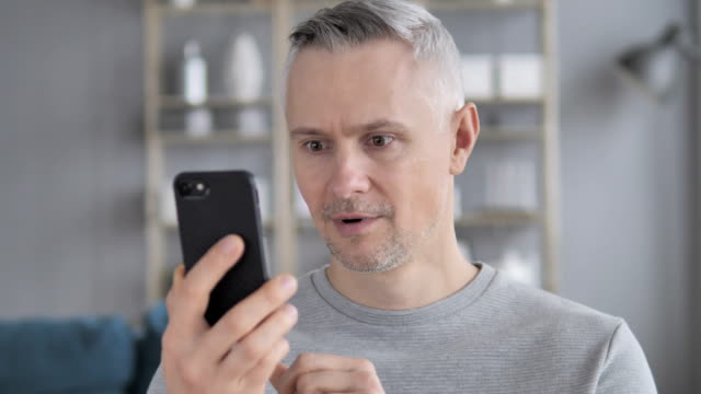 Aufgeregt,-graue-Haare-Mann-gewinnen-Online-auf-Tablet