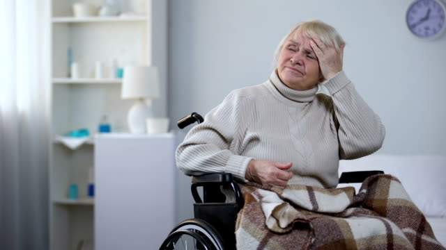 Ältere-Frau-im-Rollstuhl-Gefühl-Kopfschmerzen,-Krankenschwester-für-Schmerzmittel